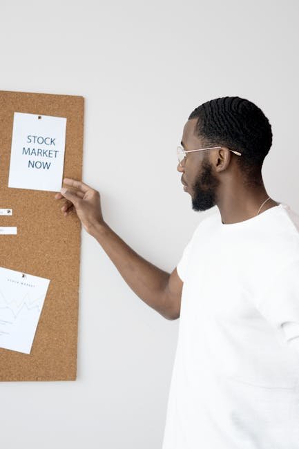 Businessman in white analyzing stock market insights on a corkboard.
